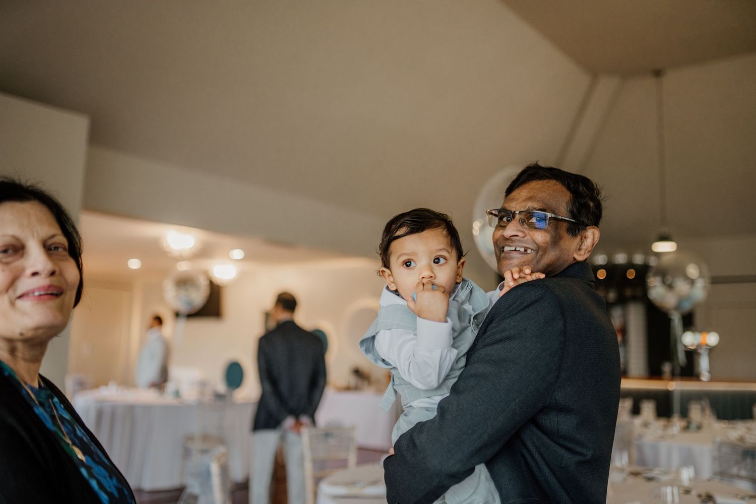 Candid moments of guests enjoying themselves at an indoor celebration.