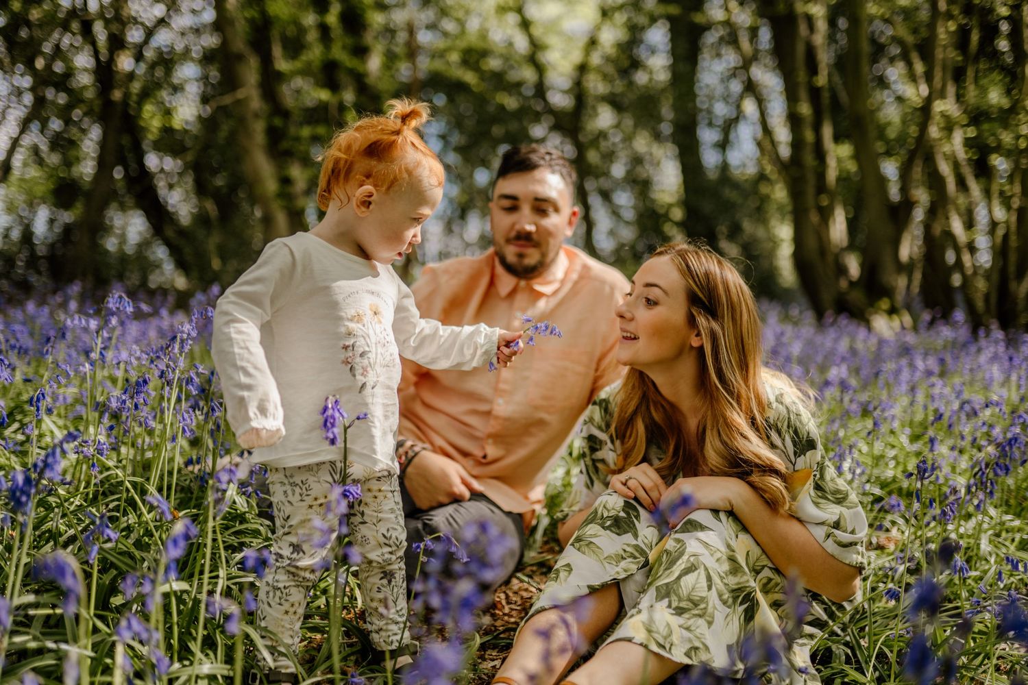 Family sitting together in the bluebells in Hertfordshire