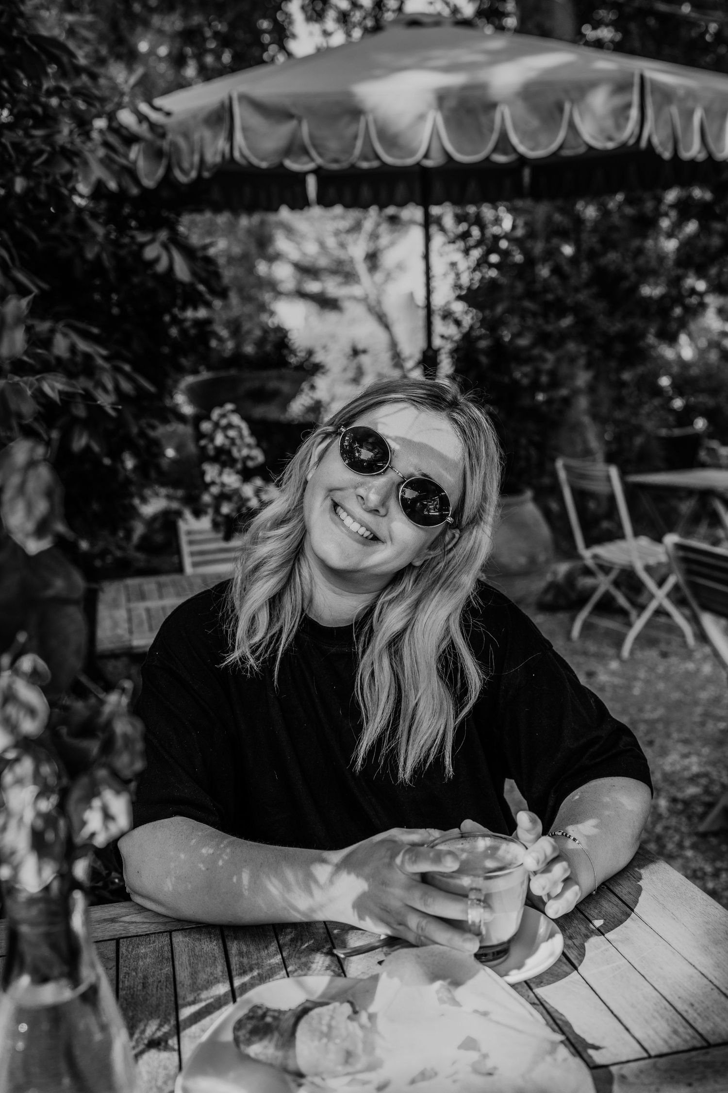 A sequence of black and white photos showing someone drinking coffee at an outdoor table.