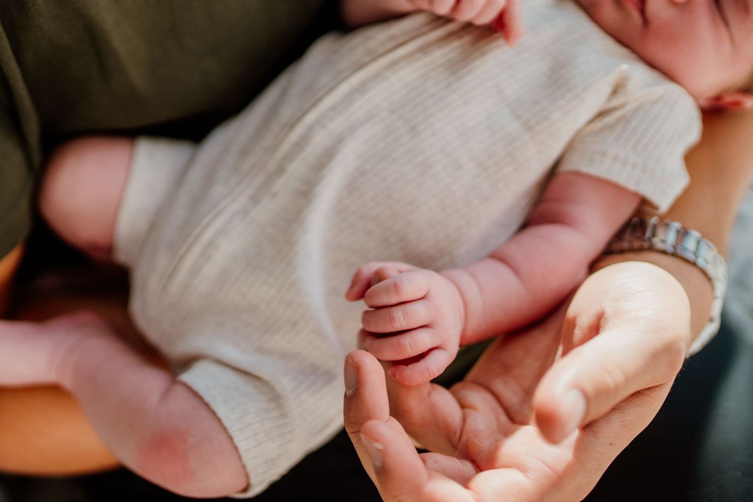 Close up details of newborn baby wearing soft knit clothing.