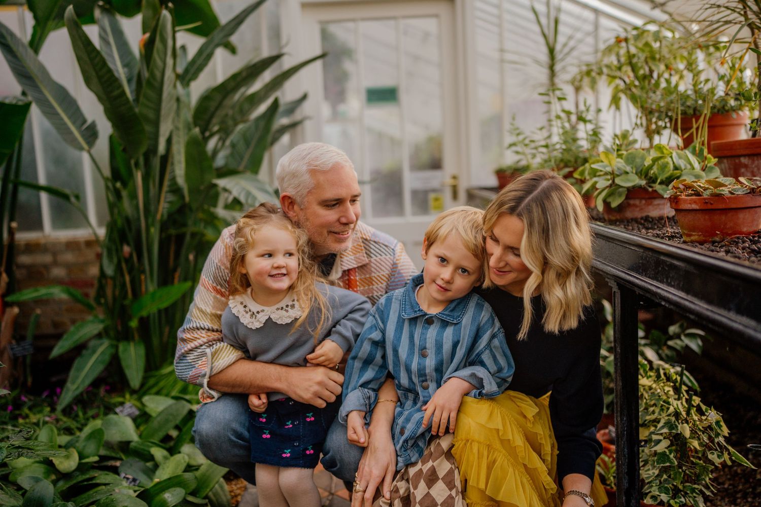 Multigenerational family shares joyful moments together on an outdoor patio with lush greenery.