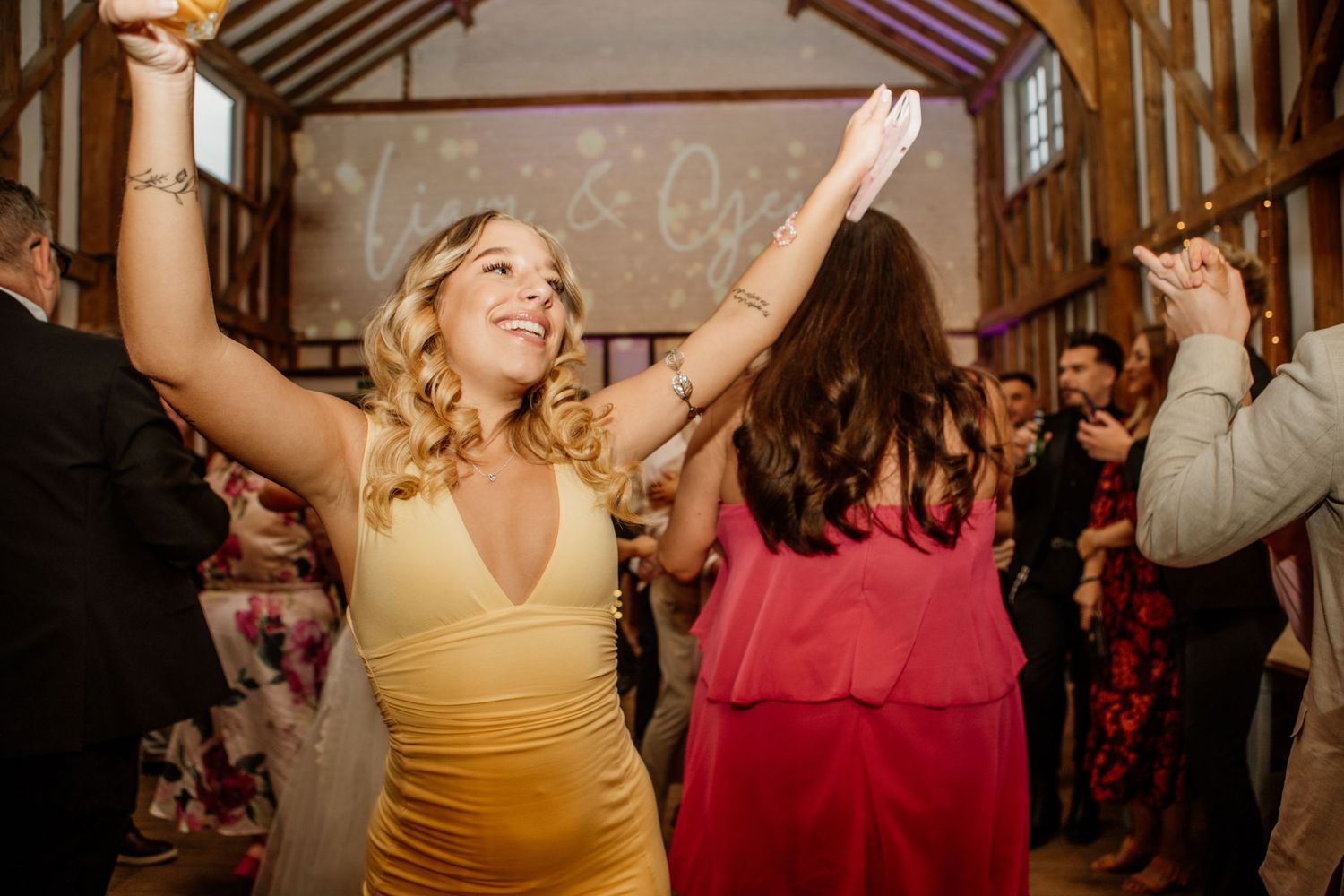 Wedding guests dancing and celebrating at a lively reception party.