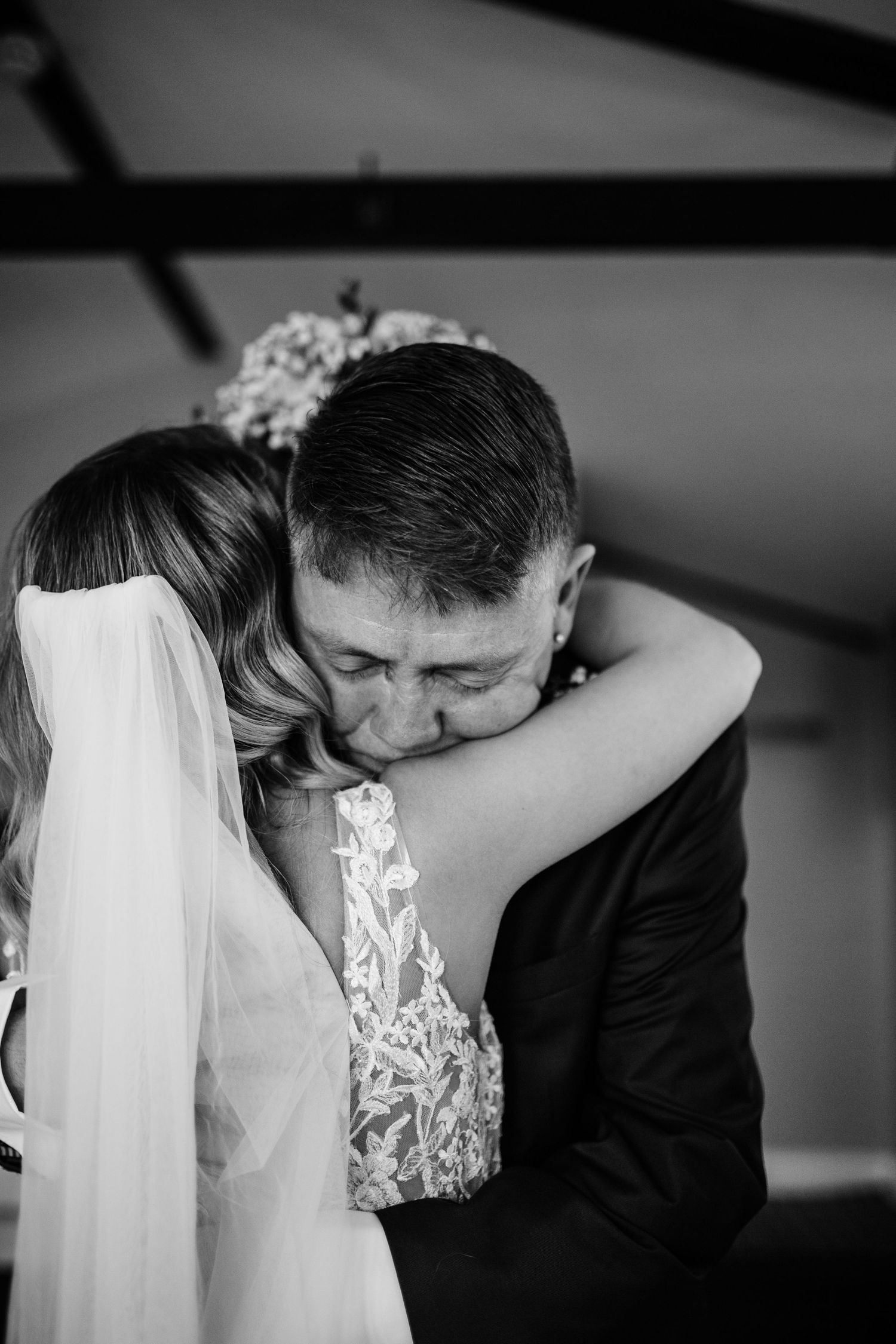 Black and white intimate wedding moment captured in dramatic lighting.