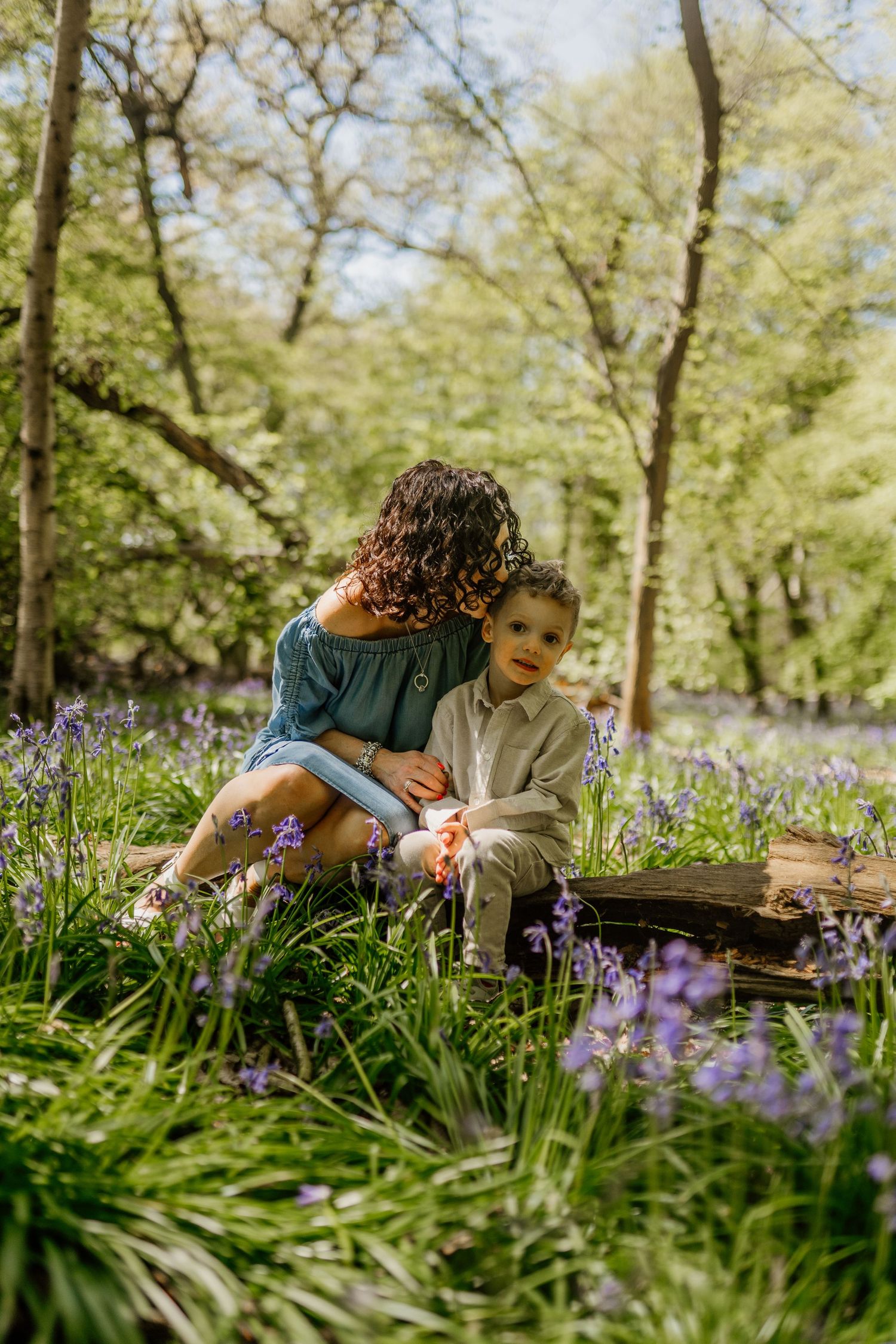 A tender moment shared between two people in a blooming spring garden filled with bluebells in Hertfordshire.