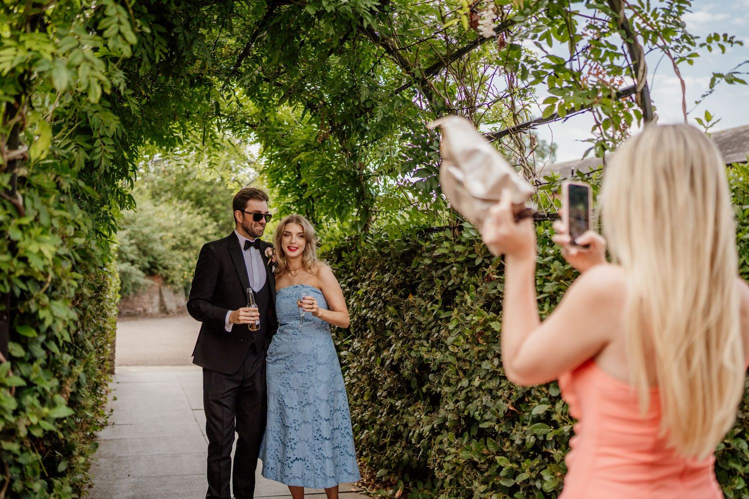 A couple shares a romantic moment in a lush garden setting during a wedding photo session.
