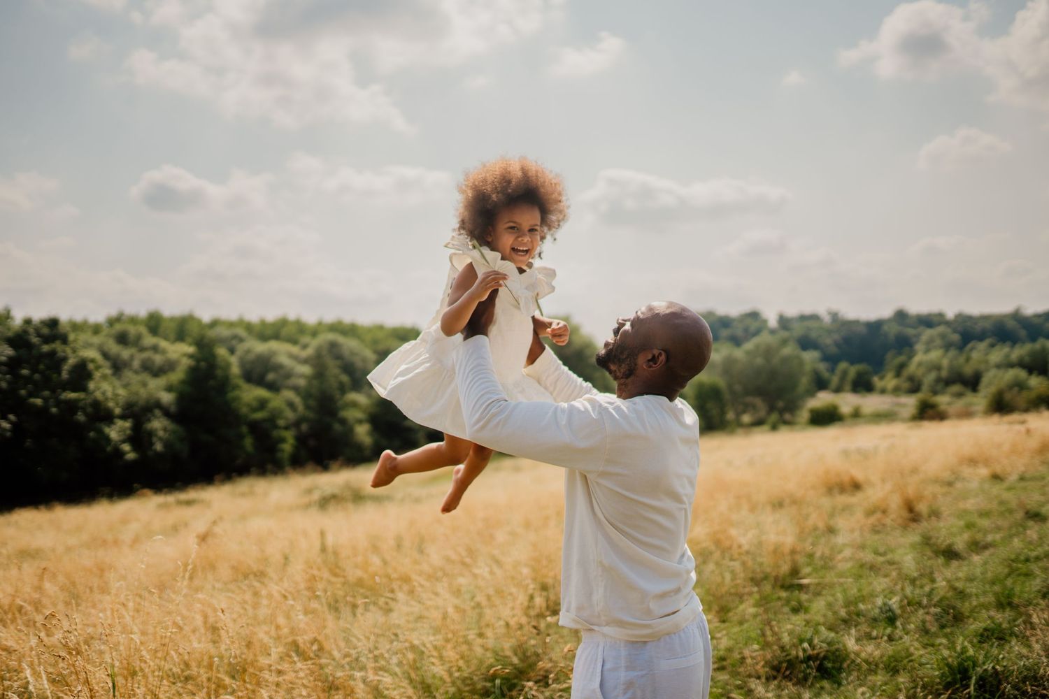 A joyful moment captured in a sunny meadow with golden afternoon light.
