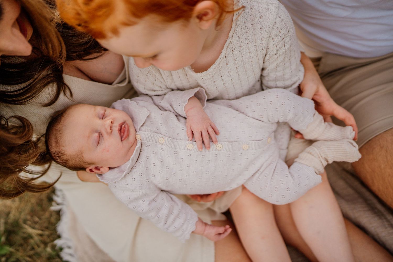Intimate family moment captured on a comfortable couch in natural light.