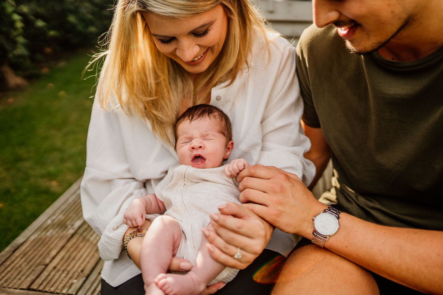 Intimate outdoor family moments with newborn baby during golden hour.