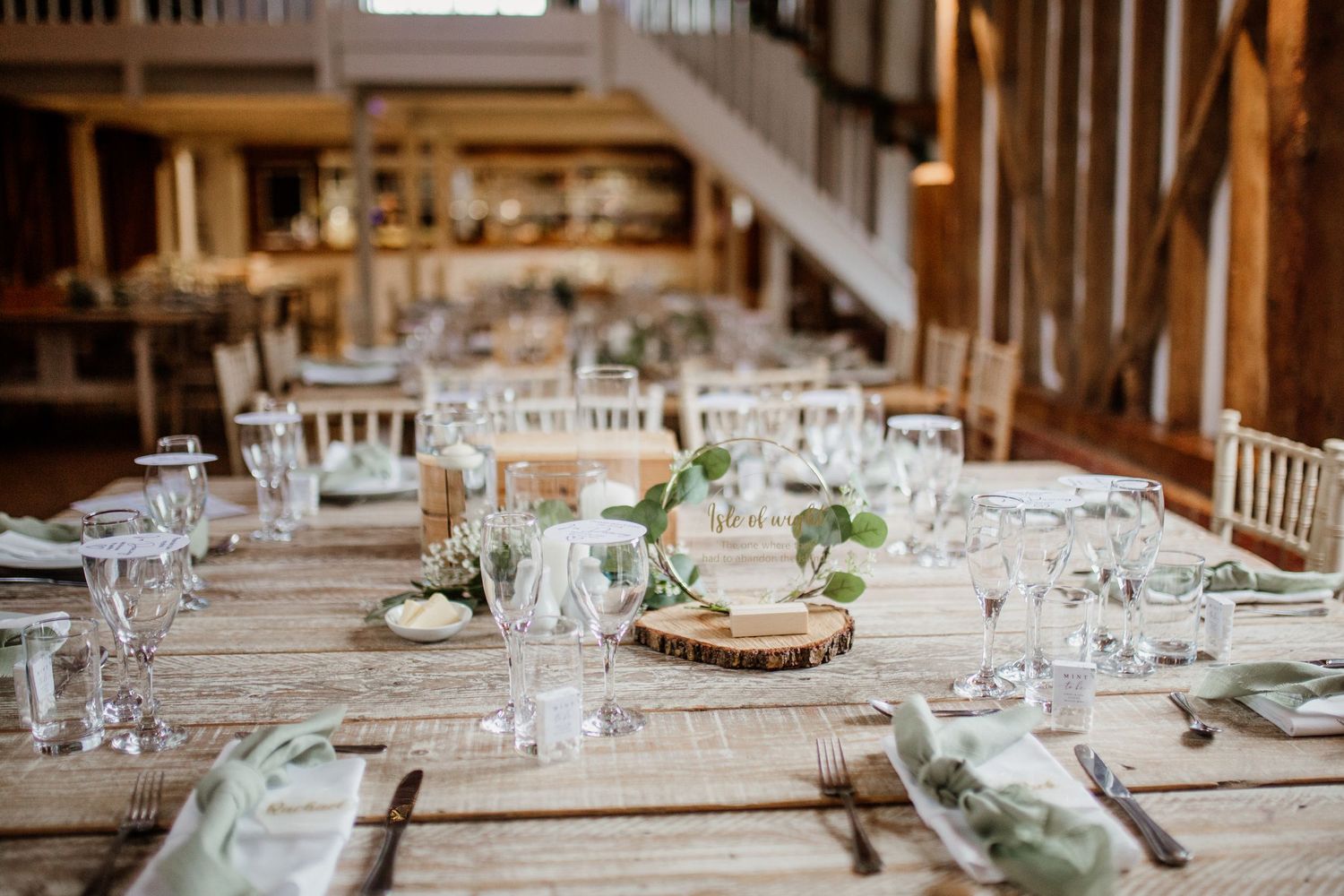 Rustic barn wedding reception with elegant table settings and wooden decor.