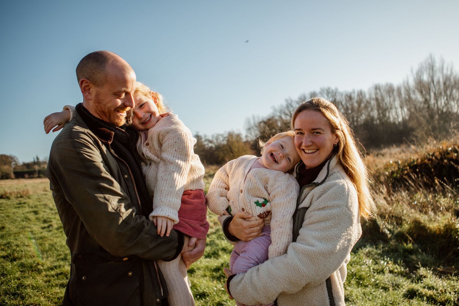Family sharing joyful moments together in a sunny outdoor setting.