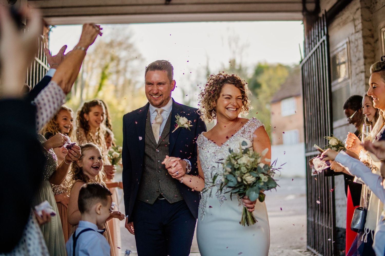 Joyful outdoor wedding celebration with guests in natural setting.