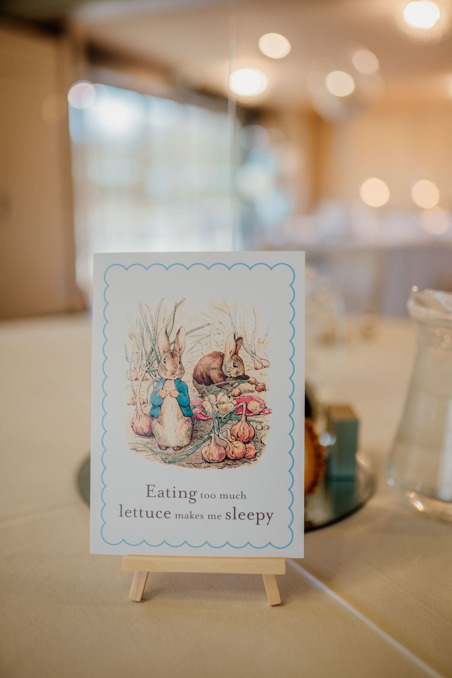 Peter Rabbit themed party decorations with storybook quotes and illustrations displayed on small stands.