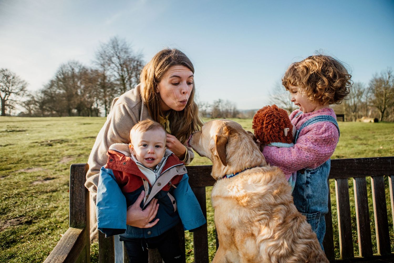 A person and a golden retriever dog share tender moments outdoors in a series of connected photos on a sunny day.