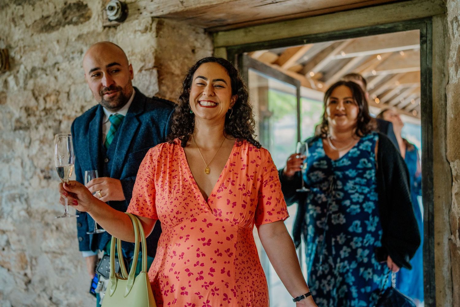 Wedding guests in colorful attire enjoying conversation at an outdoor venue.