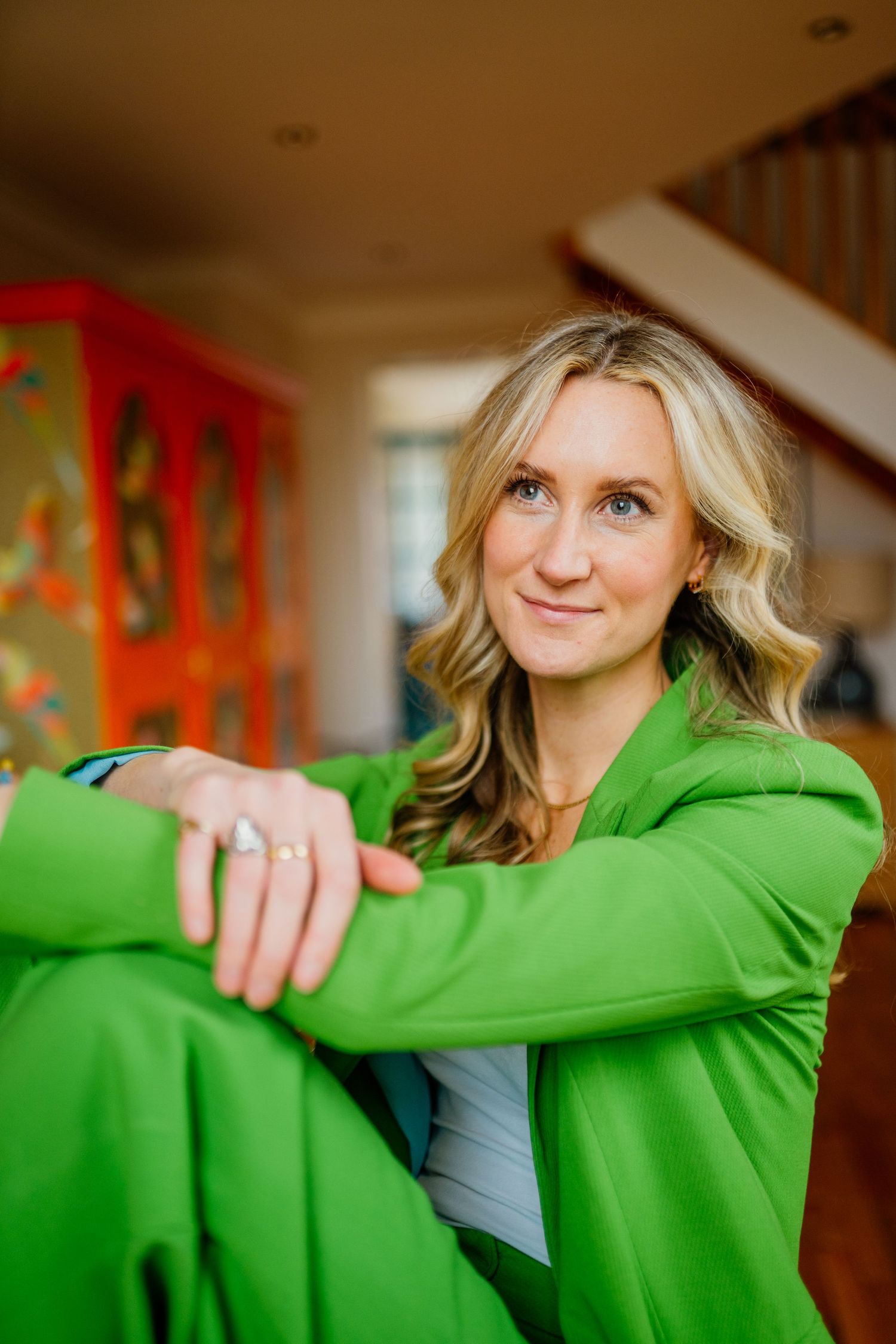 Person wearing a bright green sweater sitting casually indoors.