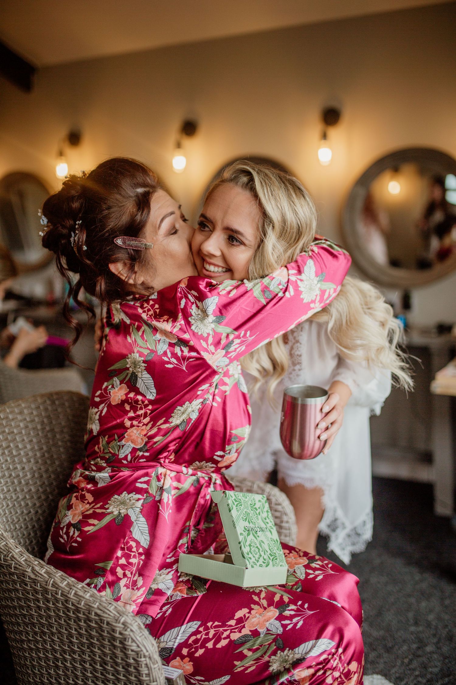 Wedding morning preparations with someone in a pink floral robe opening gifts.