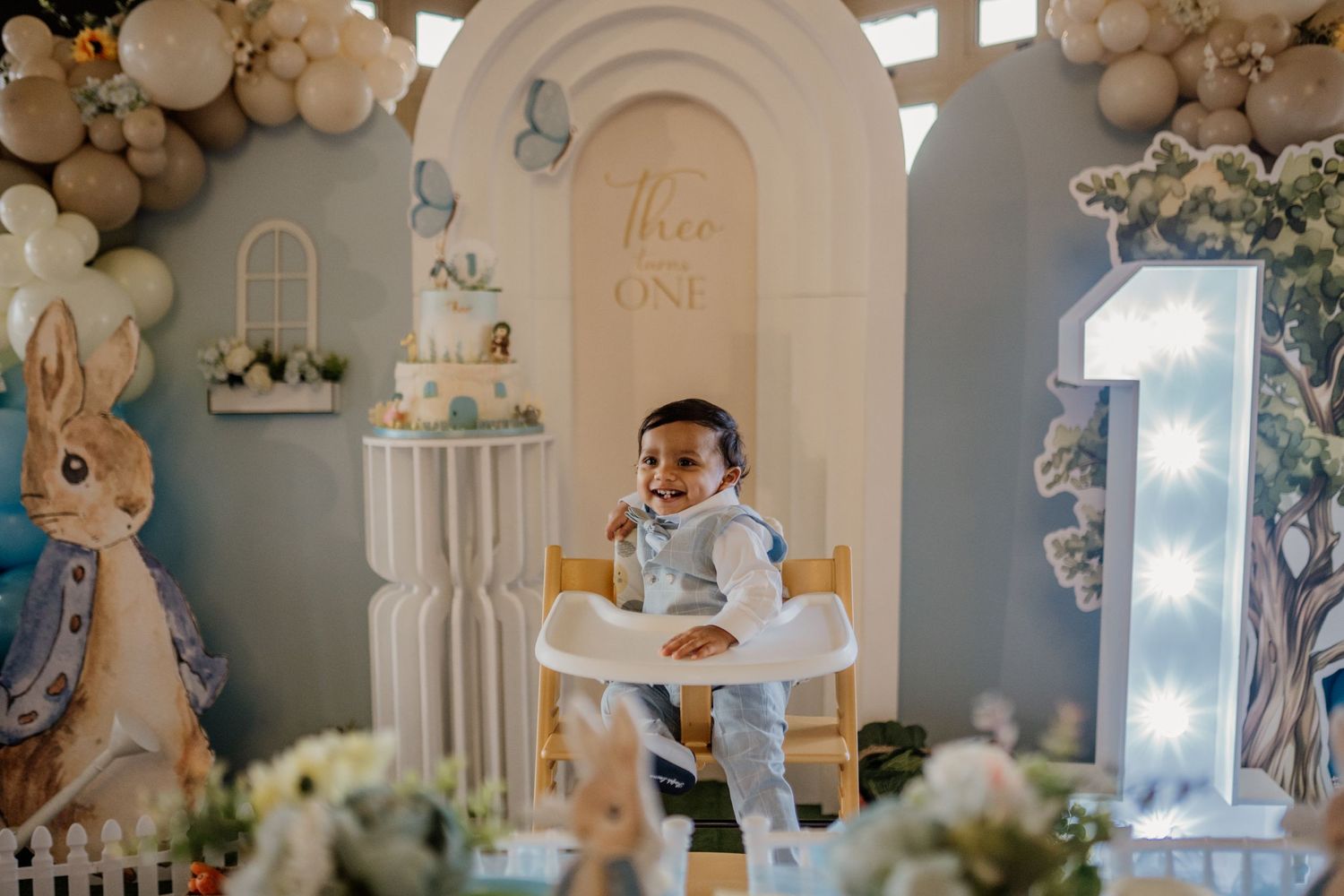 Elegant party decor with white arches, balloon garlands, and soft lighting creating a dreamy atmosphere.