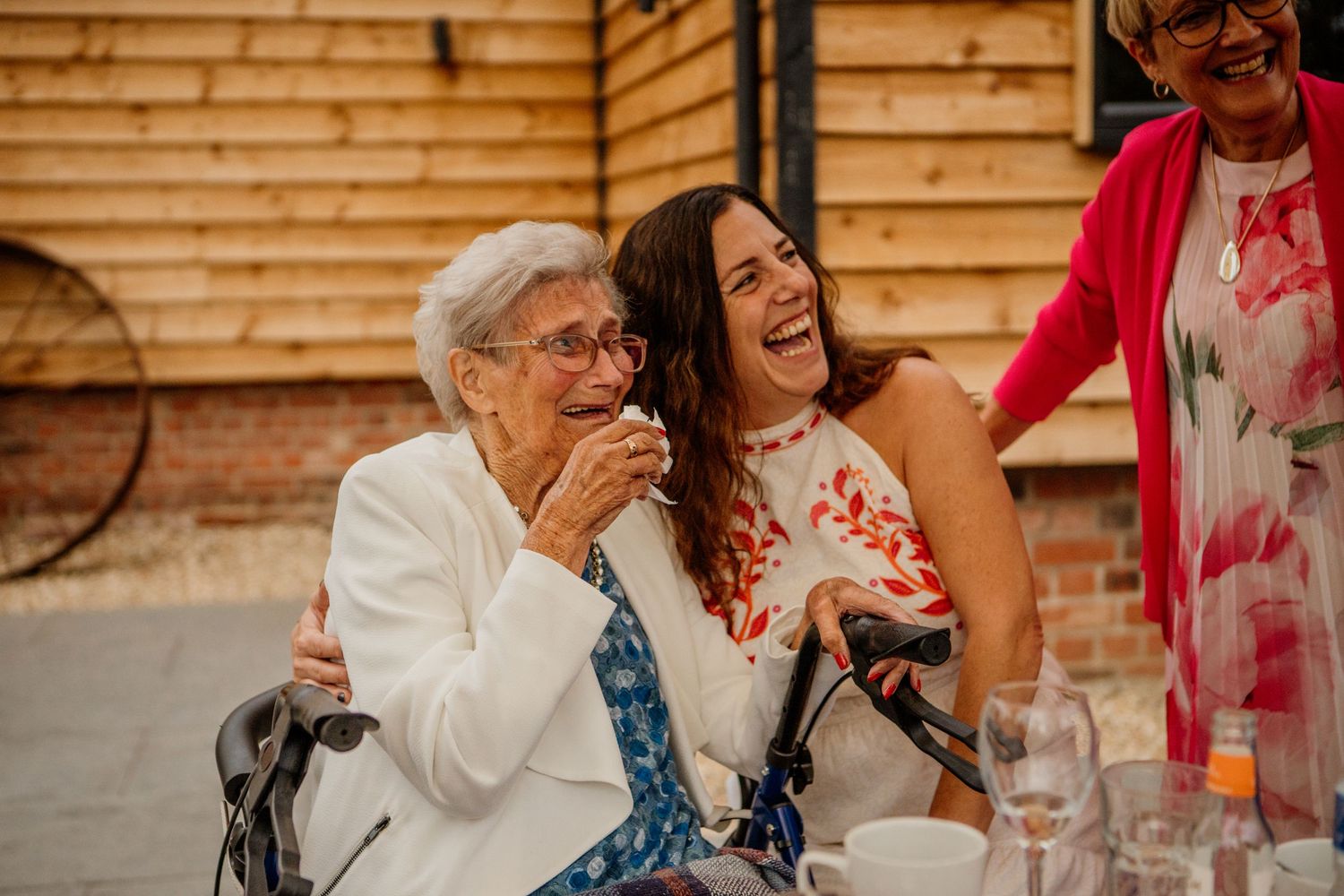 Wedding guests laughing and celebrating during outdoor reception party.
