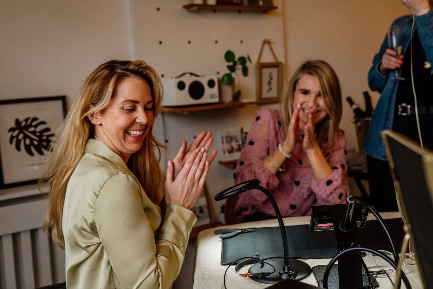 Casual interactions in a warmly lit room with plant decor and artwork.