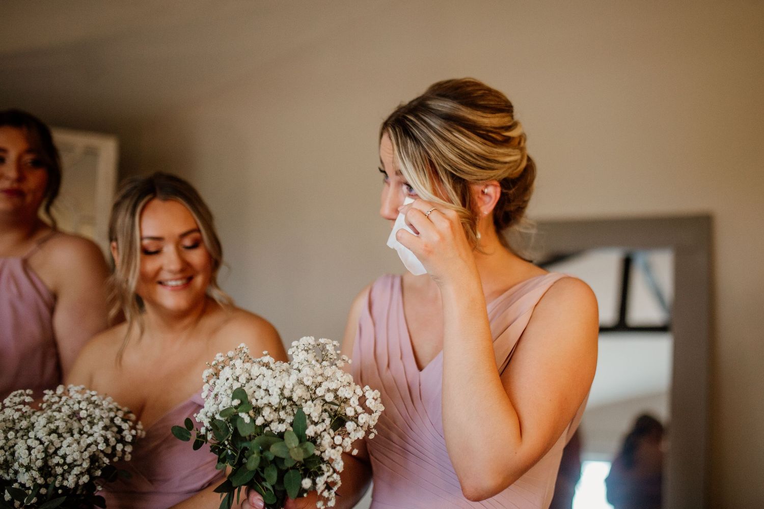 Emotional wedding party moment with baby's breath bouquets.