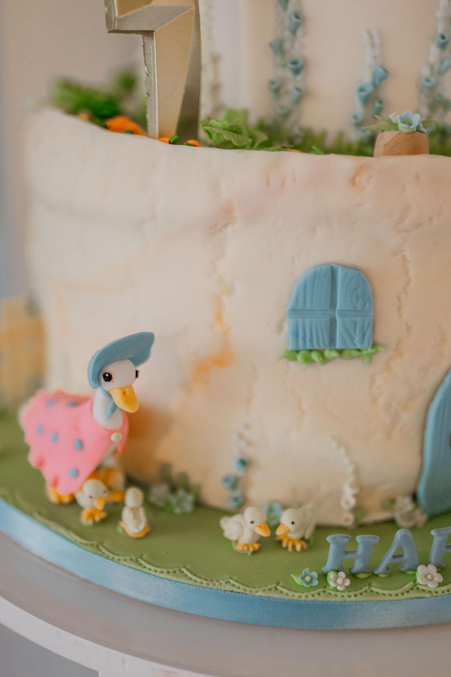White birthday cake decorated with cute animal figures and blue accents around the sides.