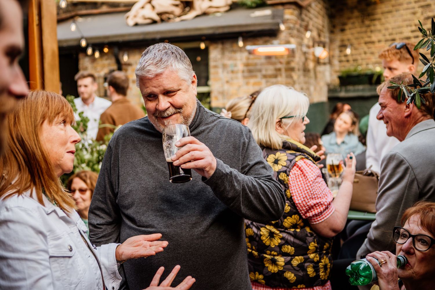 Guests mingling and socializing at a rustic indoor celebration.