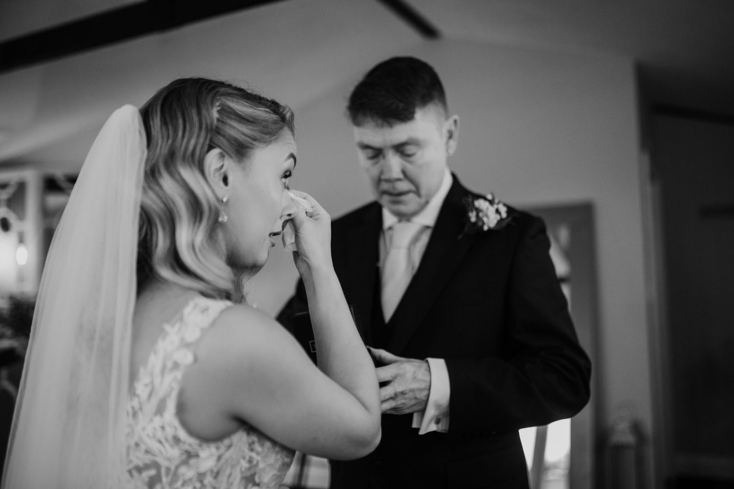 A touching black and white moment between a bride and her loved one as they prepare for the wedding ceremony.