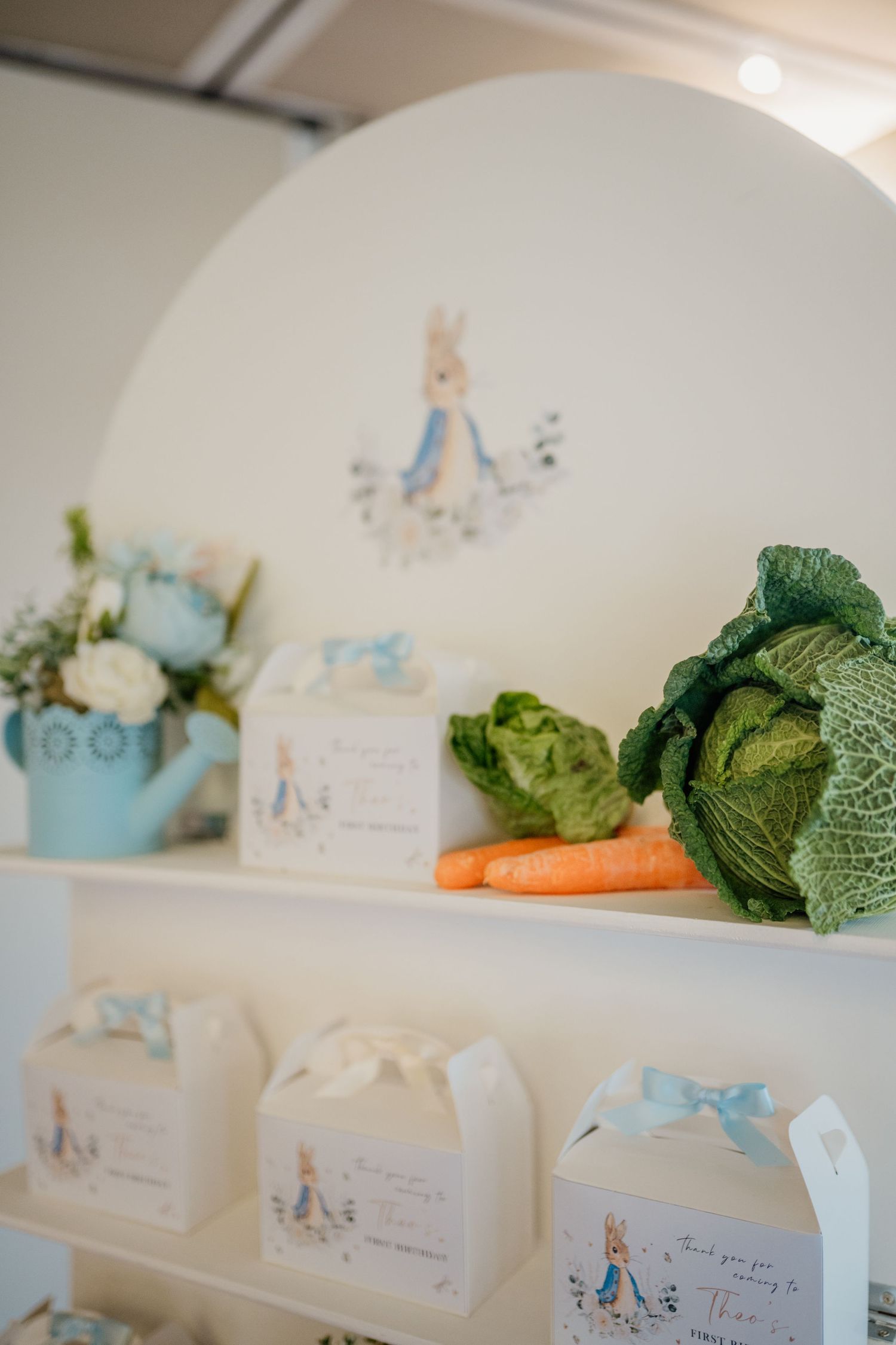 Party decor featuring fresh vegetables and Peter Rabbit themed place cards on display.