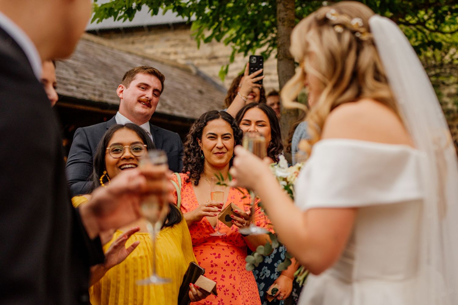 Wedding guests react with excitement during an outdoor celebration.