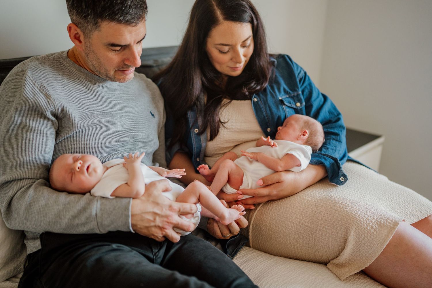 Family relaxing together on a couch during an intimate in-home photography session.