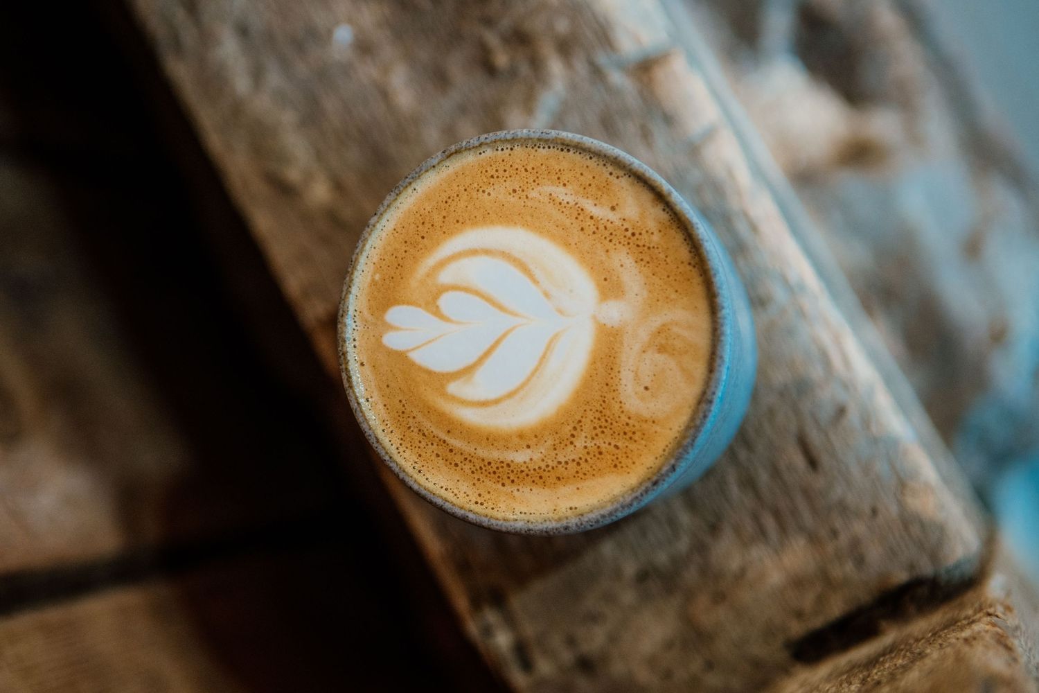A sequence of artistic latte art designs showing various leaf and heart patterns in coffee foam against dark backgrounds.