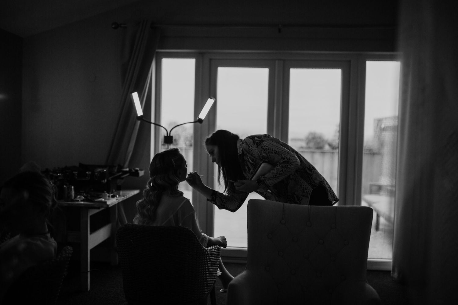 Moody silhouette of a room with natural light streaming through windows.