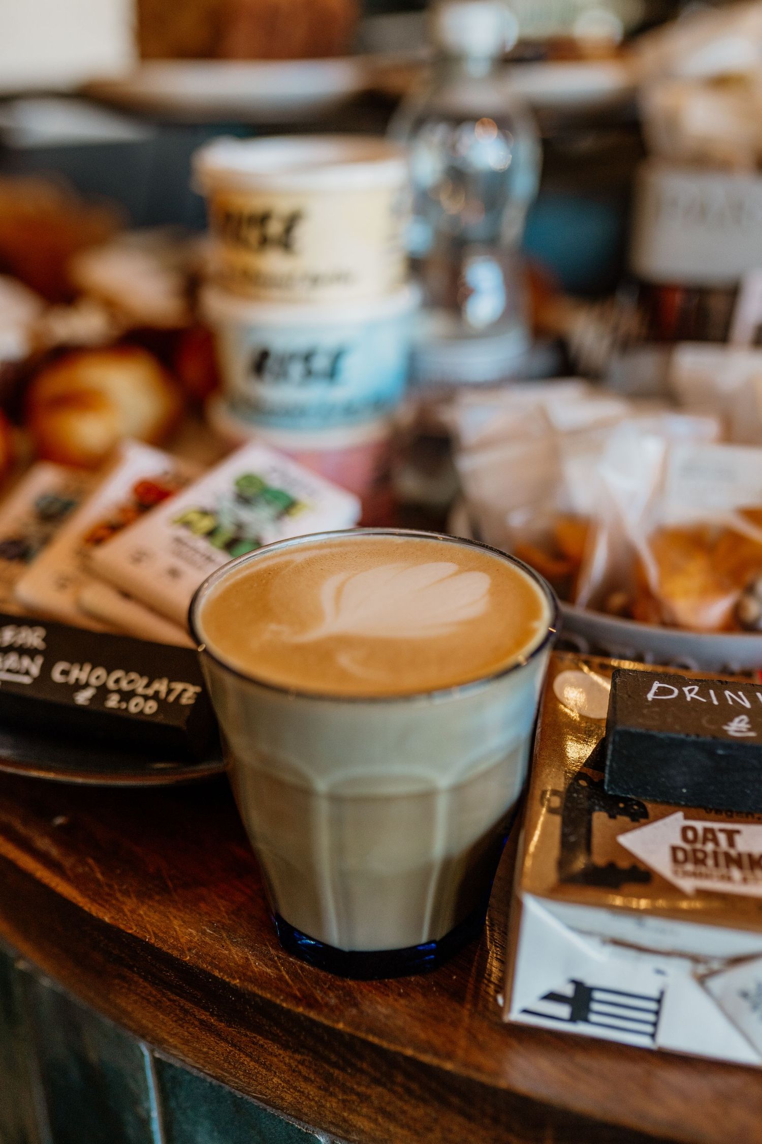 Artisanal coffee drinks with latte art served in white ceramic cups on wooden table.