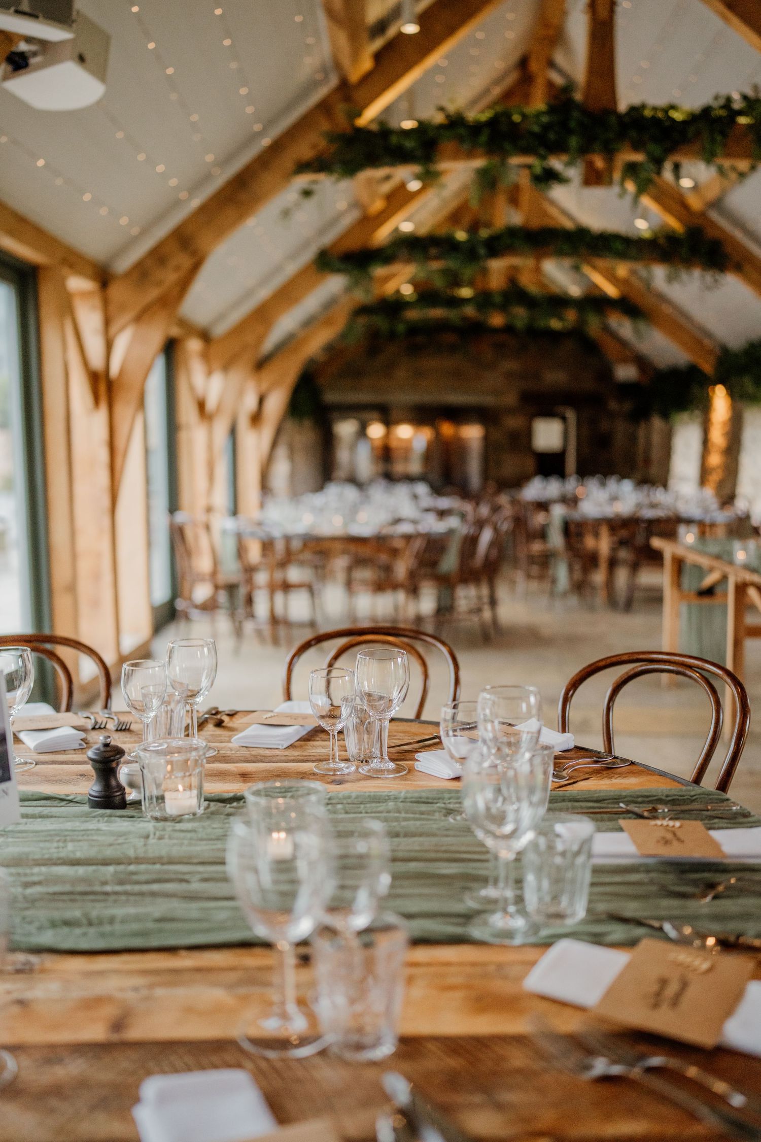 Rustic wedding reception venue with wooden beams and elegant table settings.