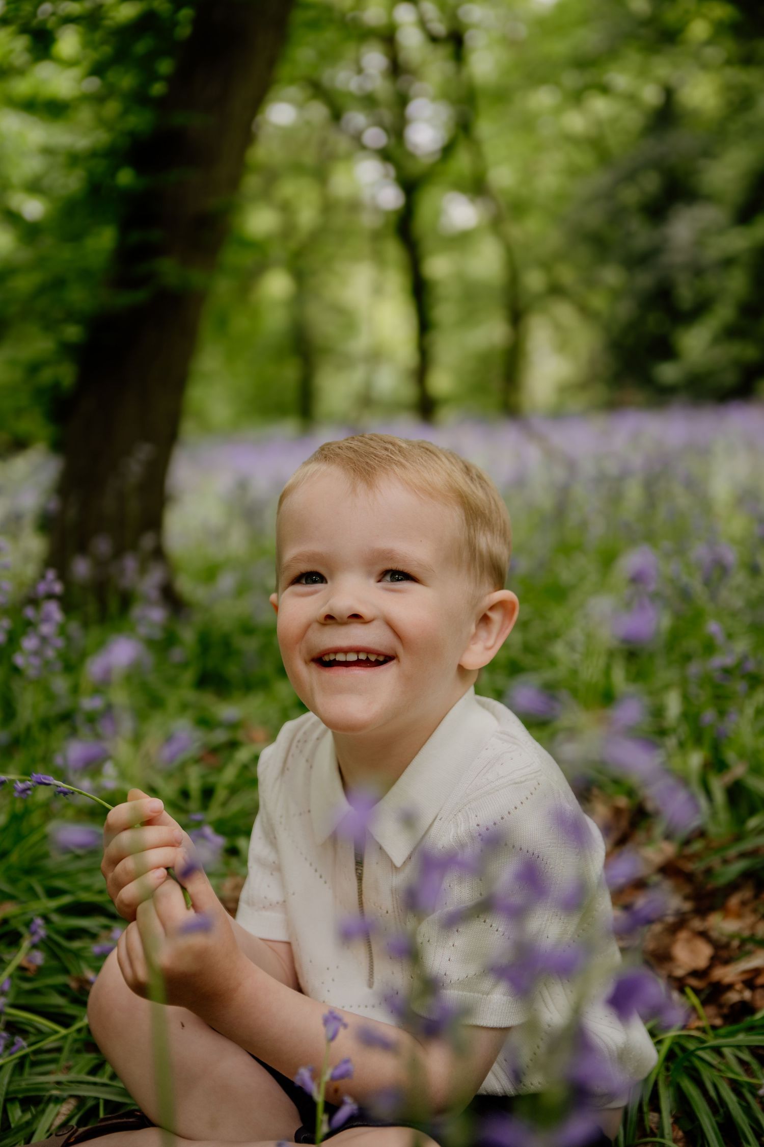 A joyful moment captured in a bluebell woodland during spring, surrounded by bluebells in Hertfordshire.