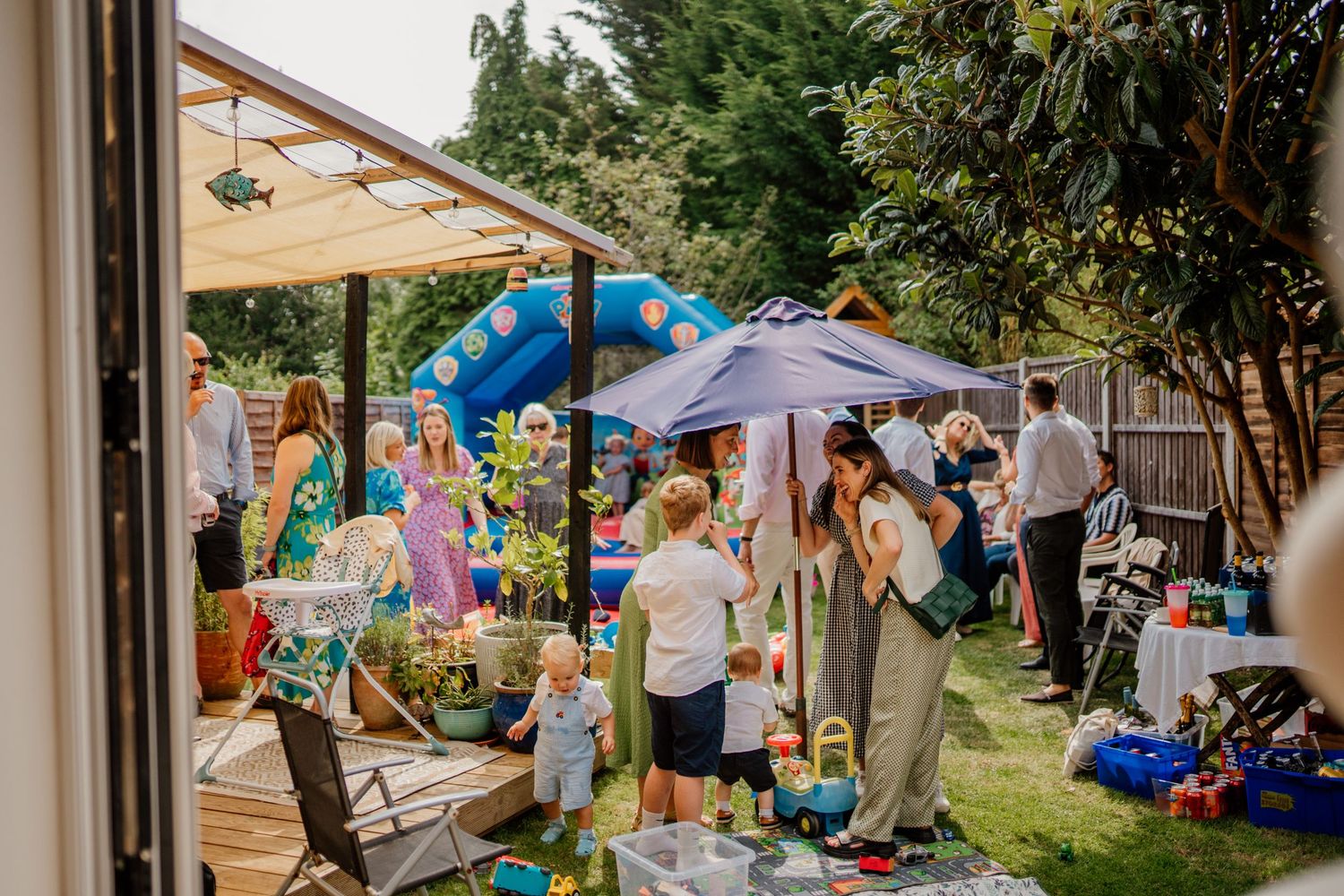 Outdoor garden party setup with tents and decorations on a sunny day.
