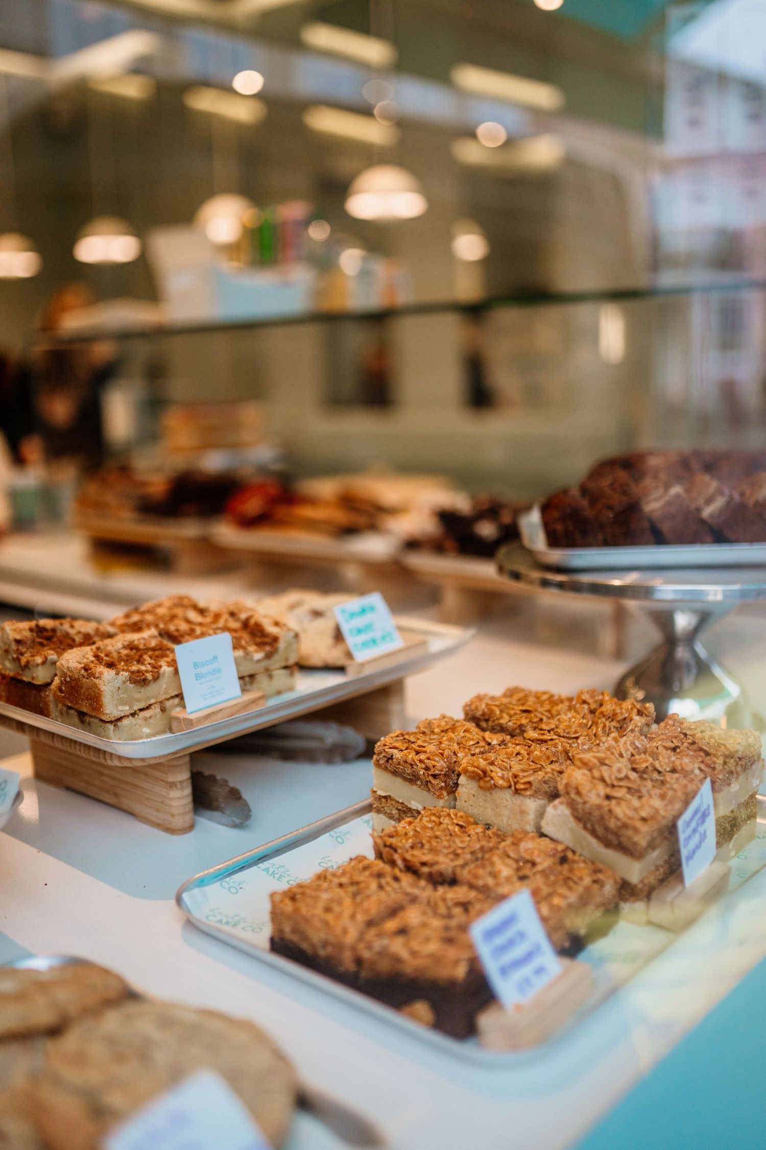Display case filled with various baked goods and desserts on wooden serving boards.