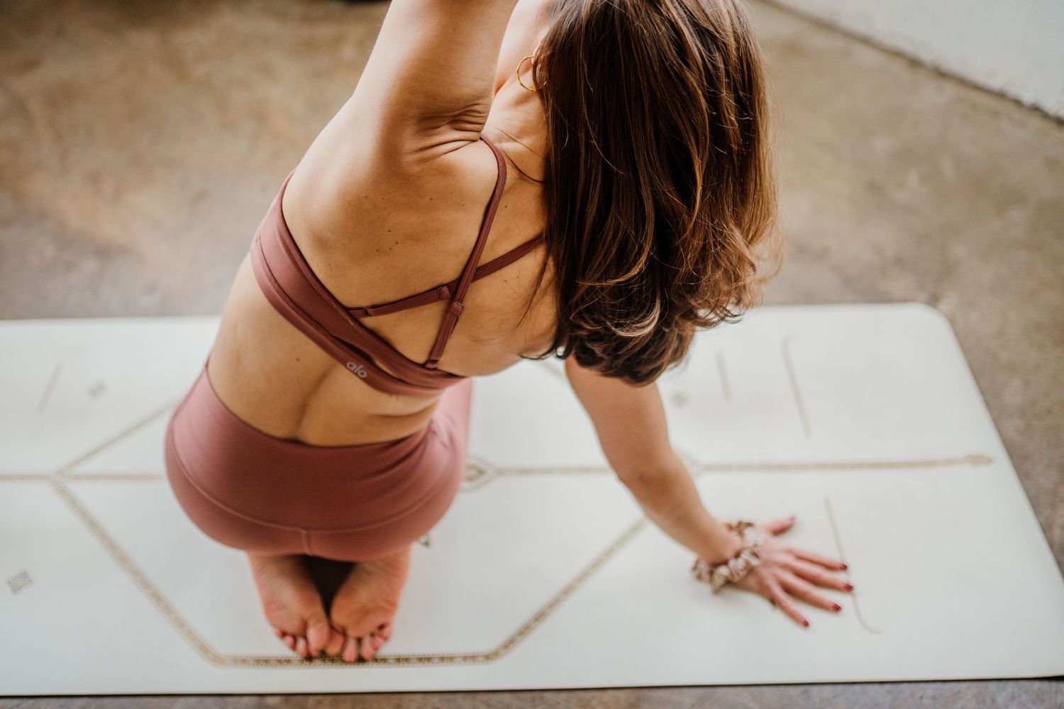 Woman practicing yoga on a white mat in a sequence of stretching poses.