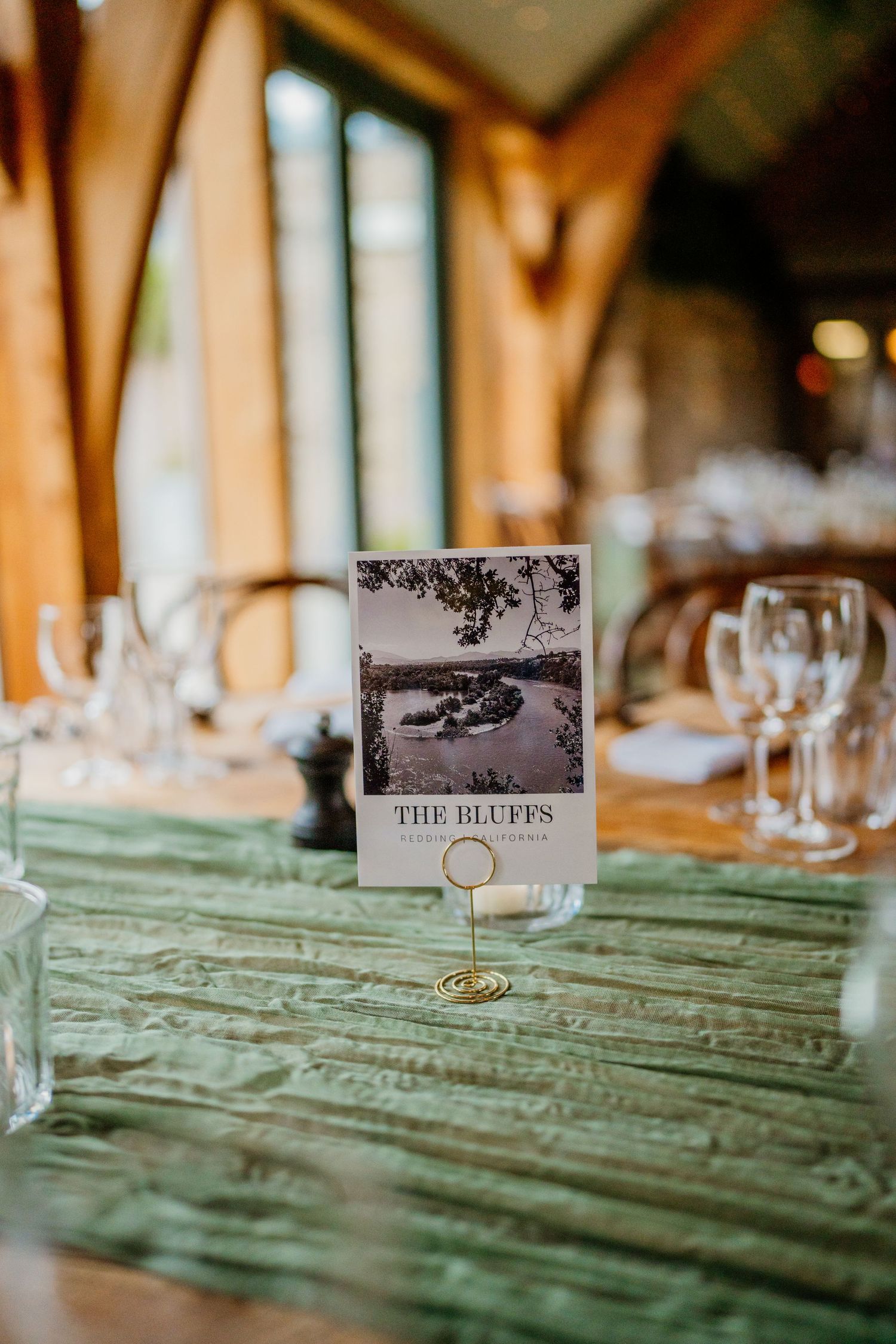 Wedding reception tables with mint green runners and vintage-style place cards.
