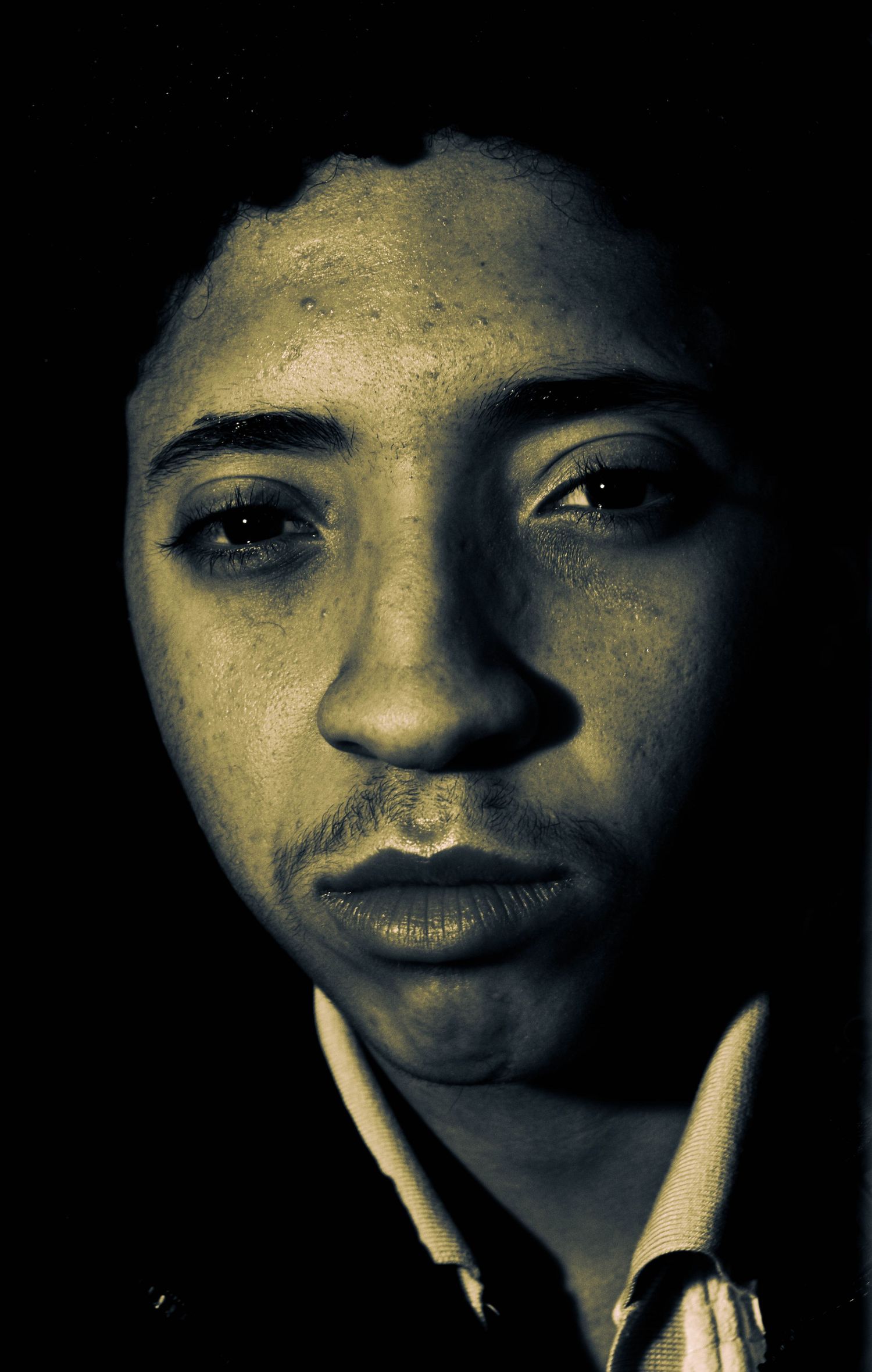 Series of close-up portraits showing different facial expressions in dramatic low-key lighting.