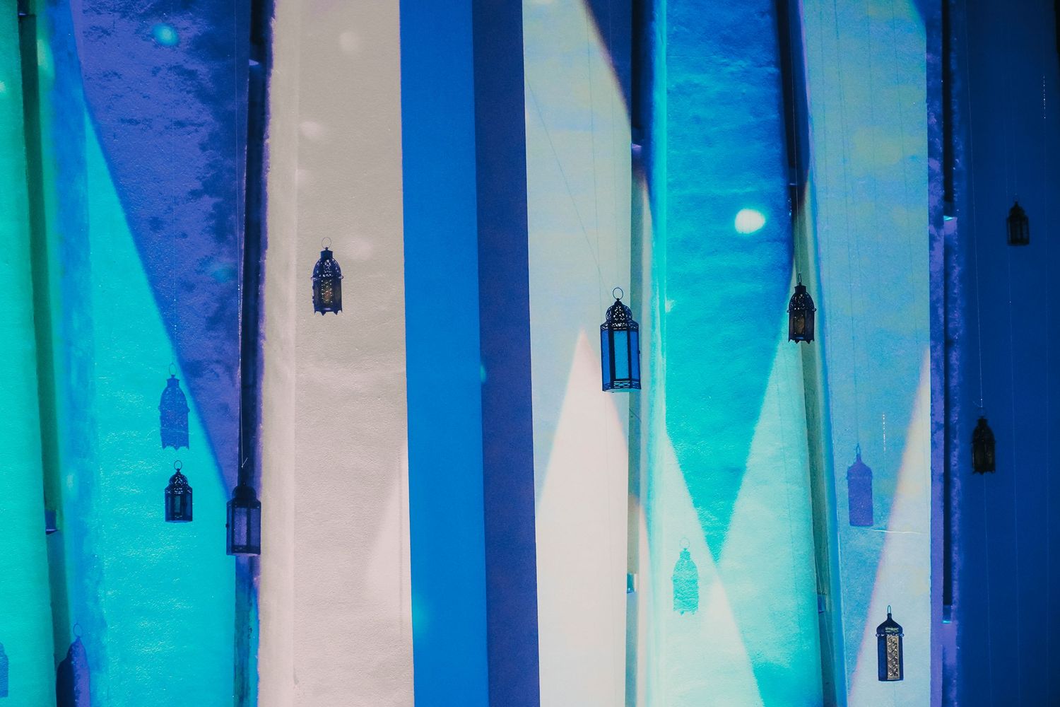 Modern interior with blue and white striped walls featuring hanging pendant lights.