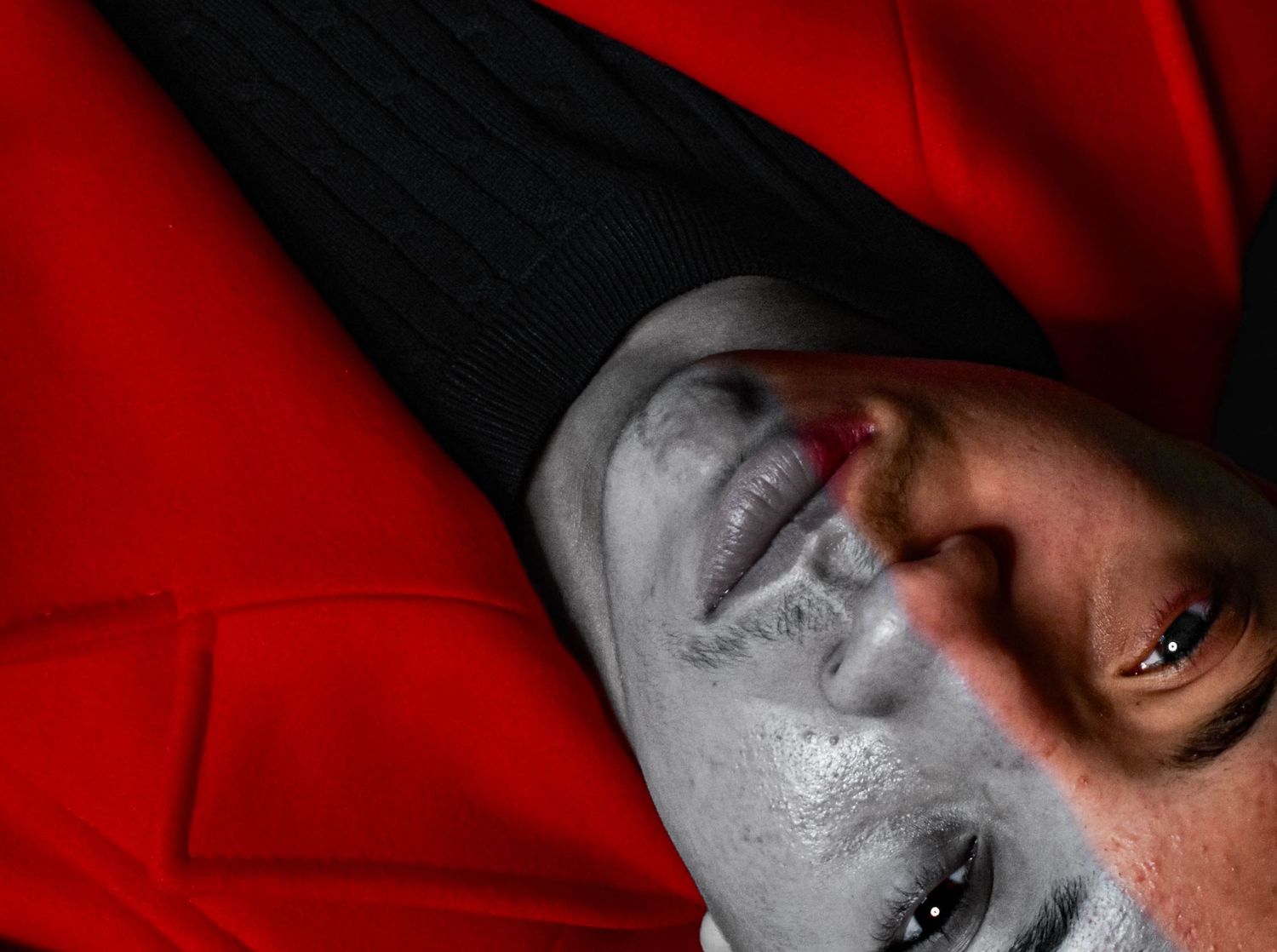 Artistic portrait with dramatic red and black lighting effects.