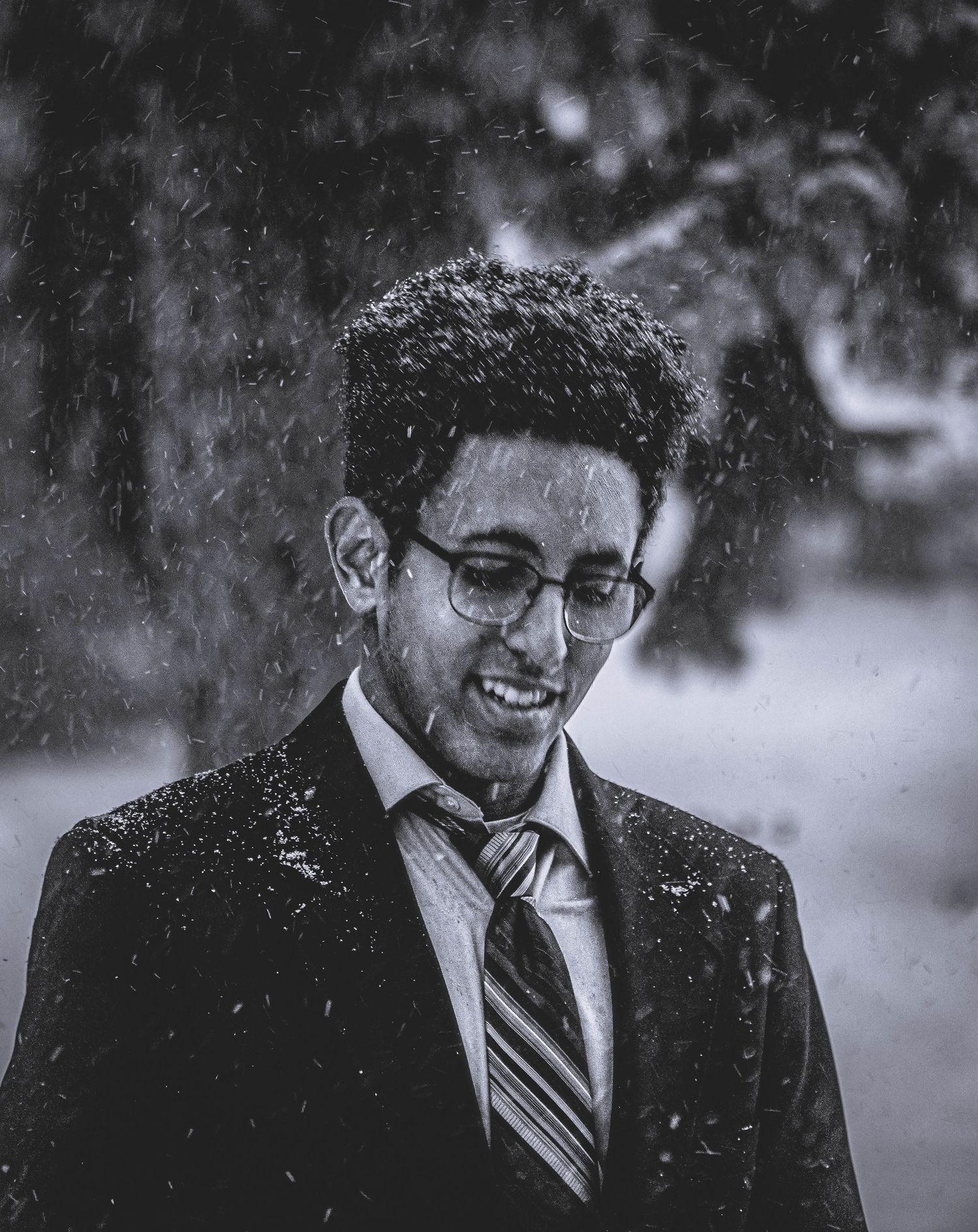 Black and white portrait sequence showing a person in glasses and tie smiling in snowy weather.