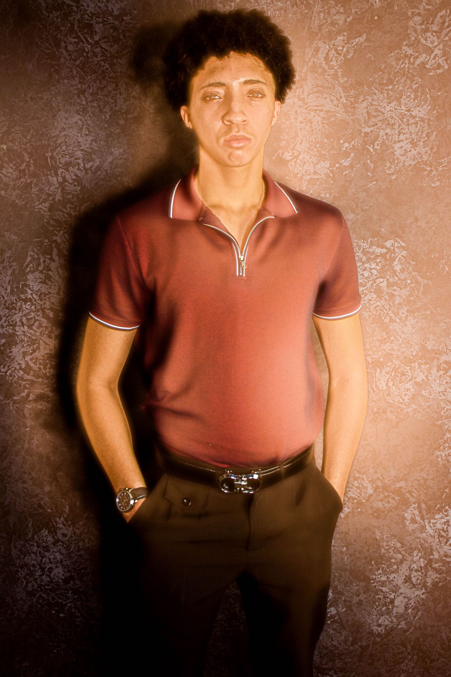 Portrait series in warm lighting showing poses in a rust-colored polo shirt.