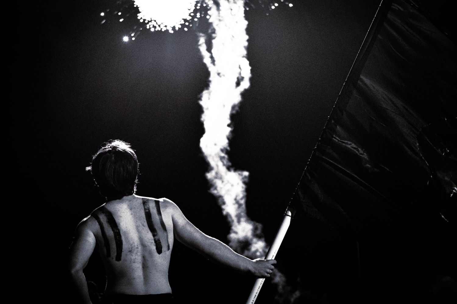 Dramatic black and white image featuring rising smoke patterns in darkness.