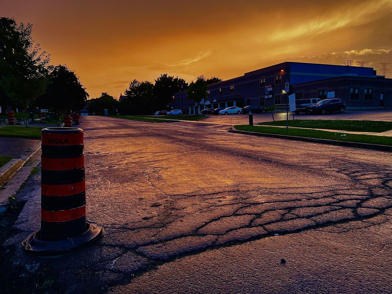 Panoramic sunset view with golden orange sky and dark silhouettes in foreground.