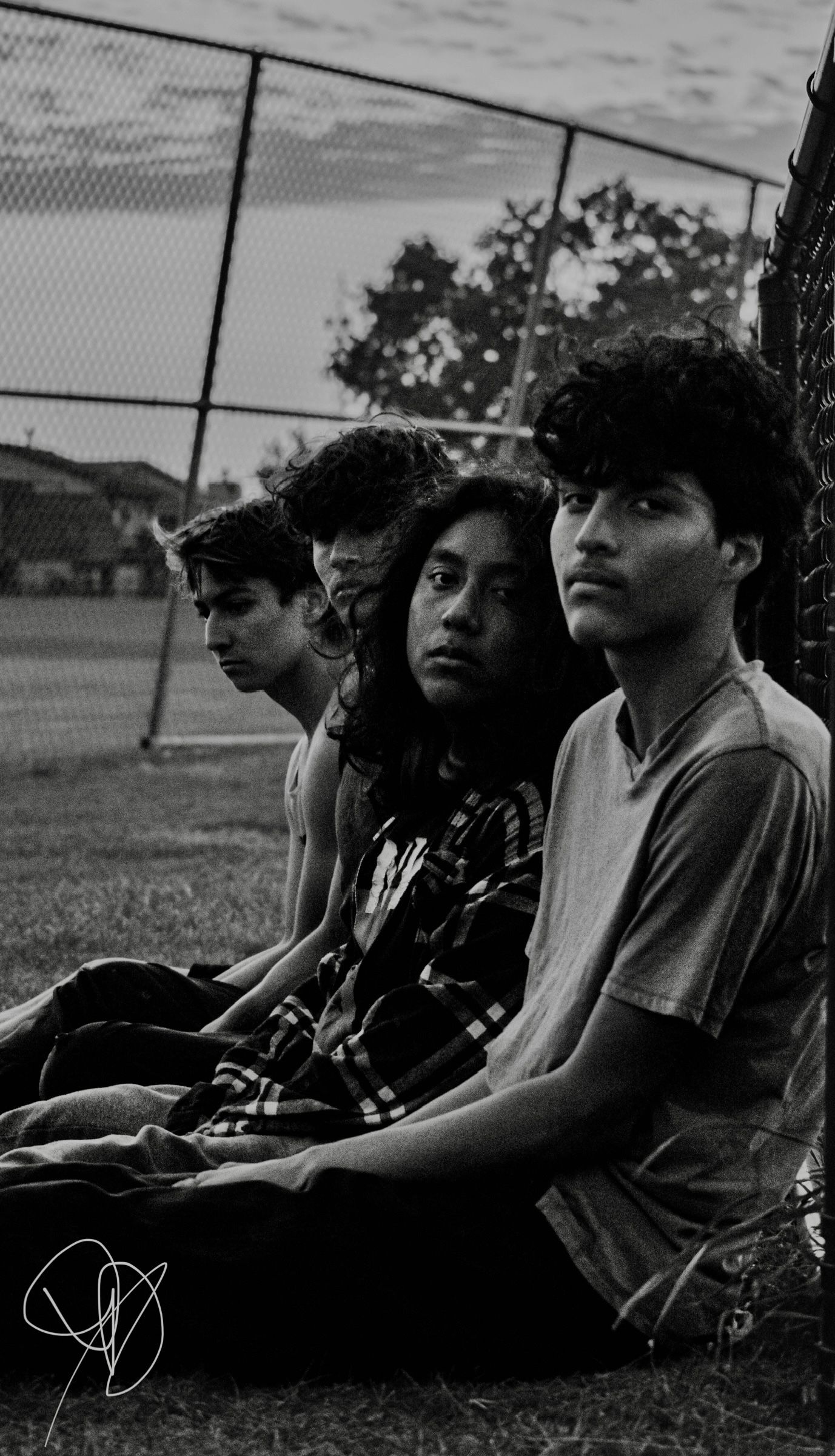 Group of people sitting together outdoors in black and white photography.