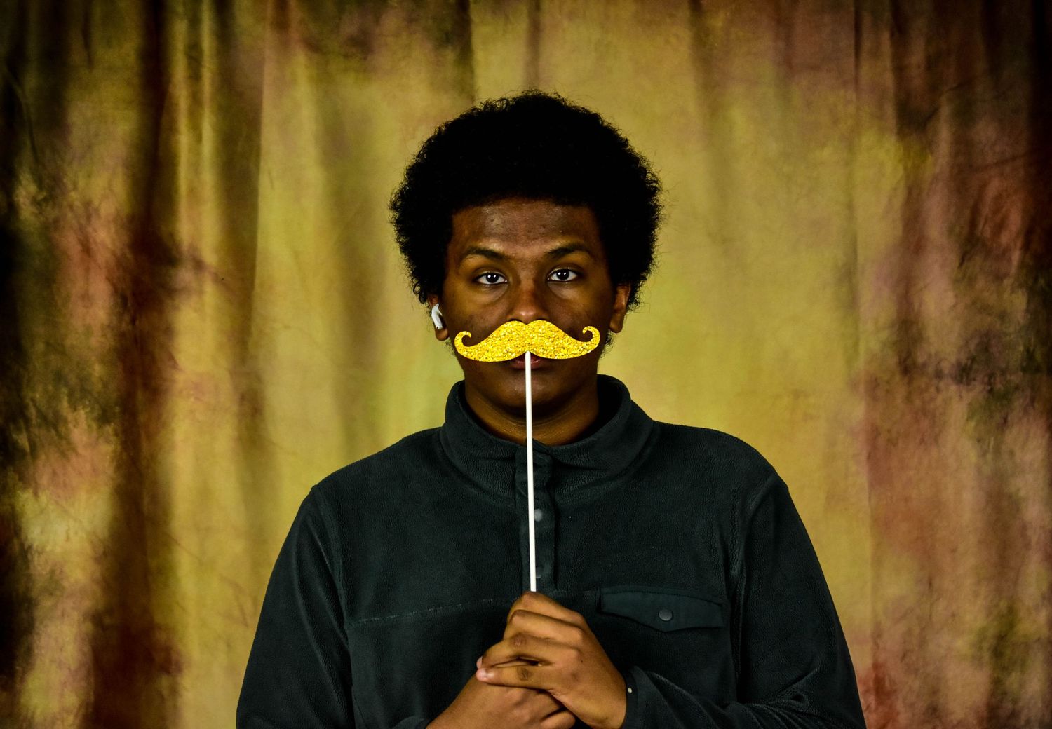 Creative portrait series with yellow prop against textured background.