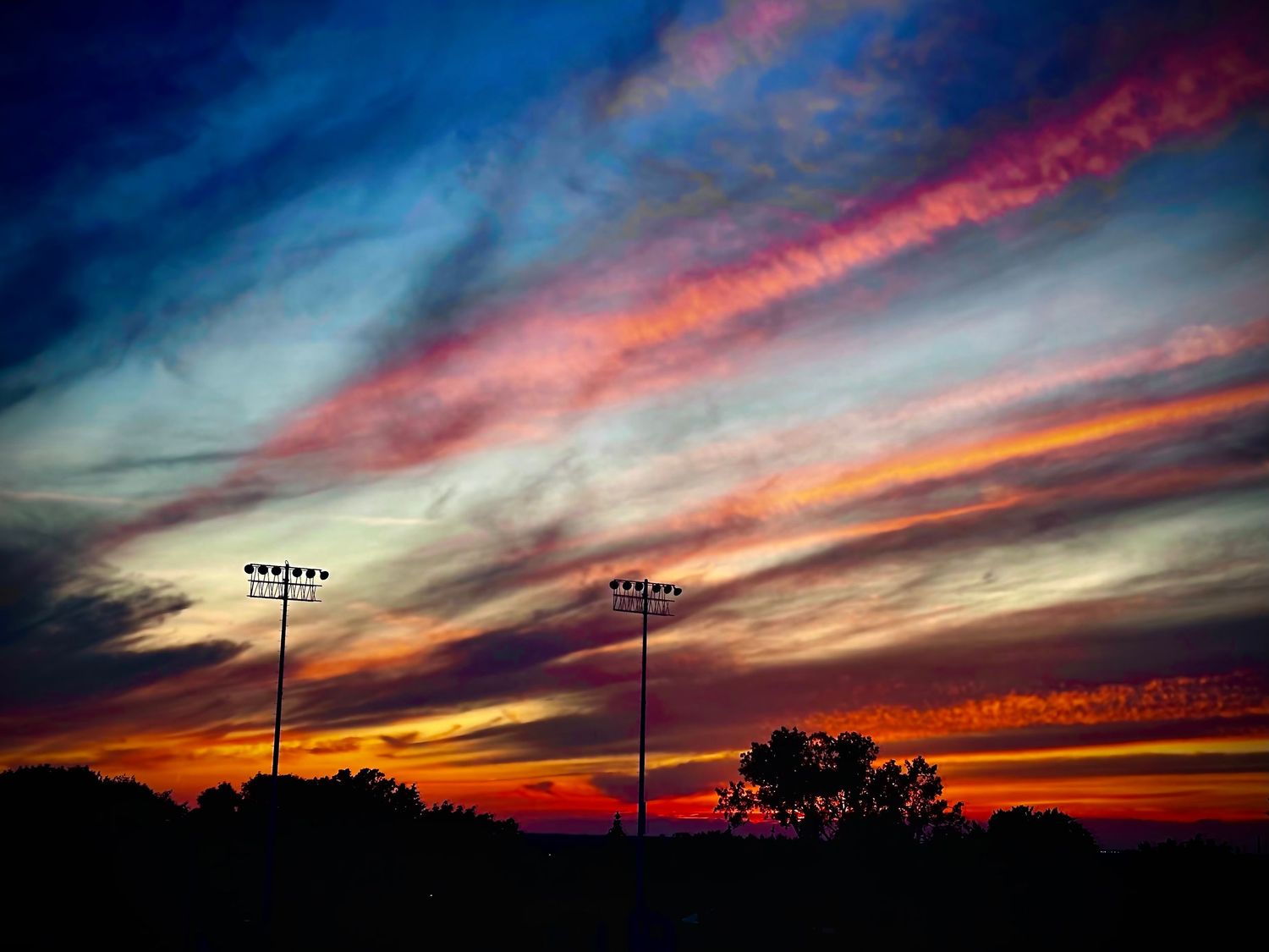 Dramatic sunset sky with vibrant pink and orange clouds stretching across the horizon.