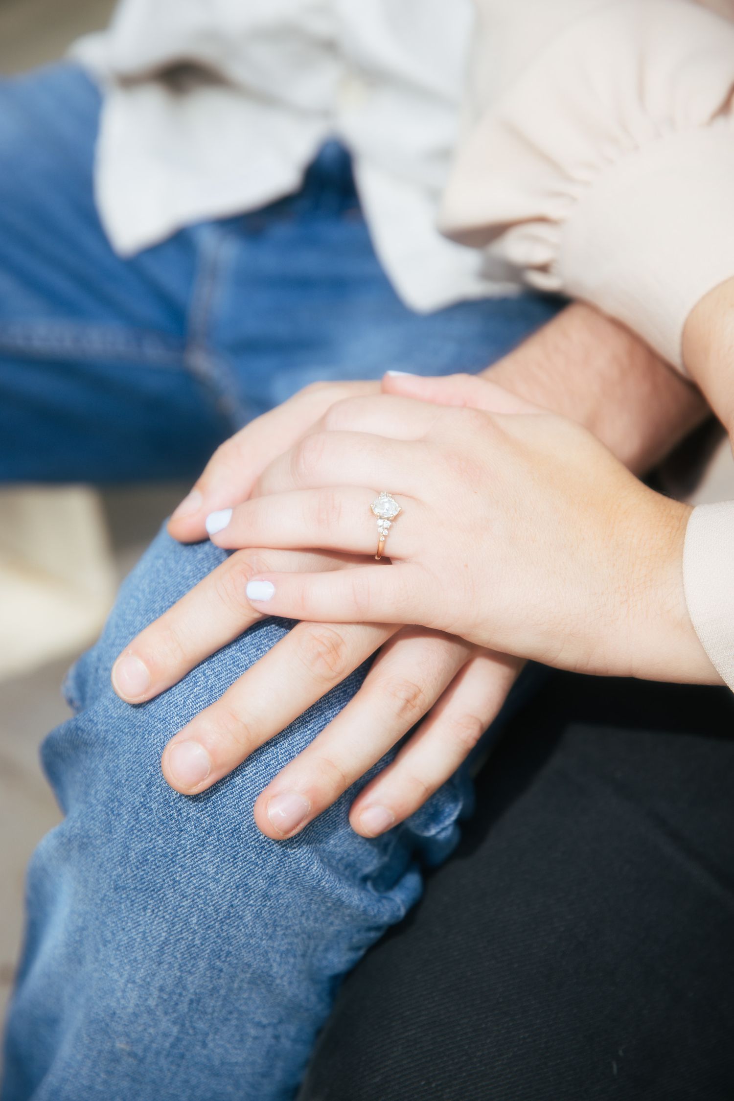 close up of hands highlighting an engagement ring
